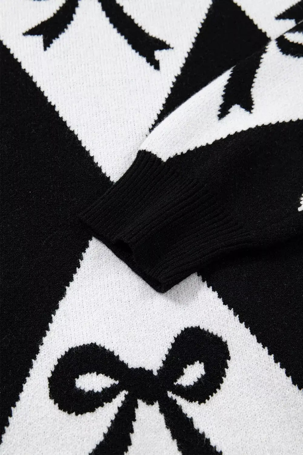 Bow Pattern Long Sleeve Contrast Sweater in black and white knit with ribbed cuffs