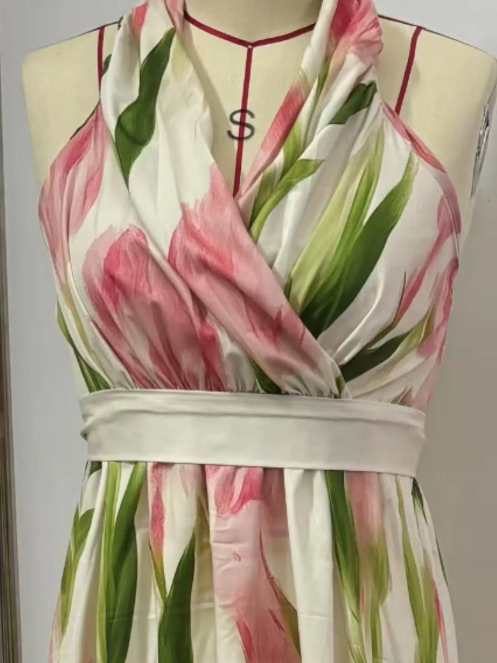 Floral print halter-neck maxi dress with pink, green, and white hues and a waist-tie sash