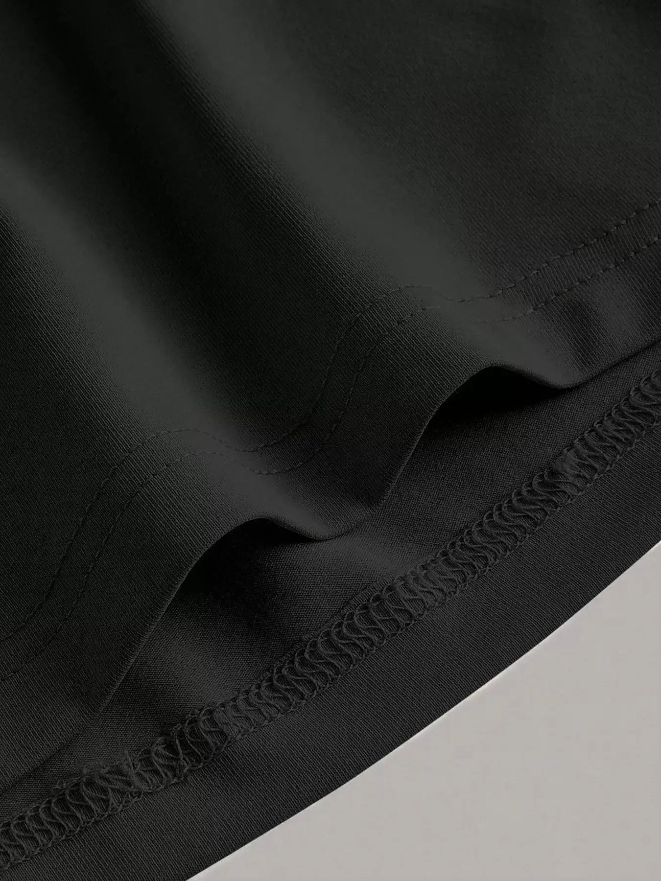 Belle Bijouix sleeveless round-neck midi dress fabric close-up in black with stretch and visible stitching.