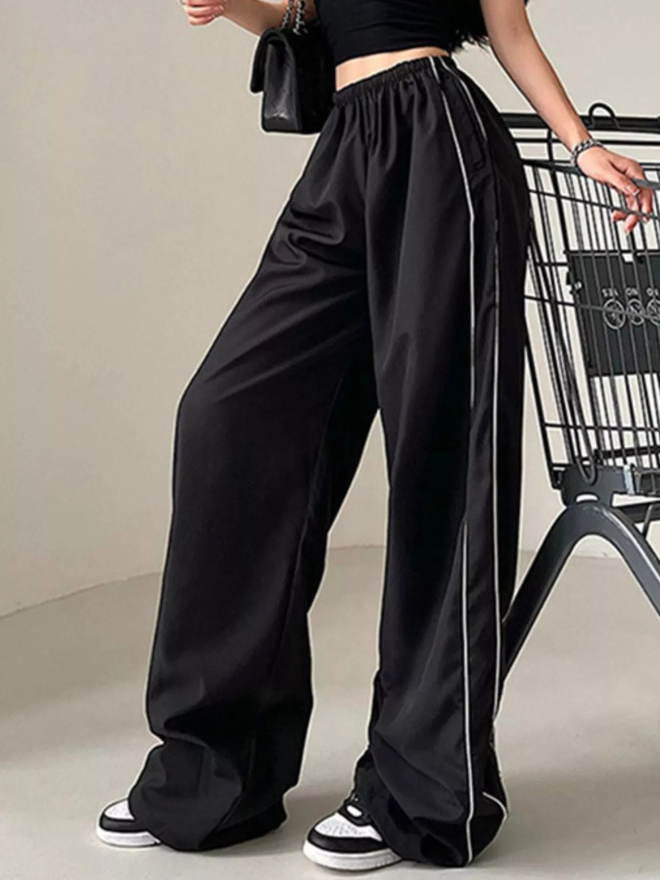 Elastic waist wide-leg pants in black with white piping, Trendsi.
