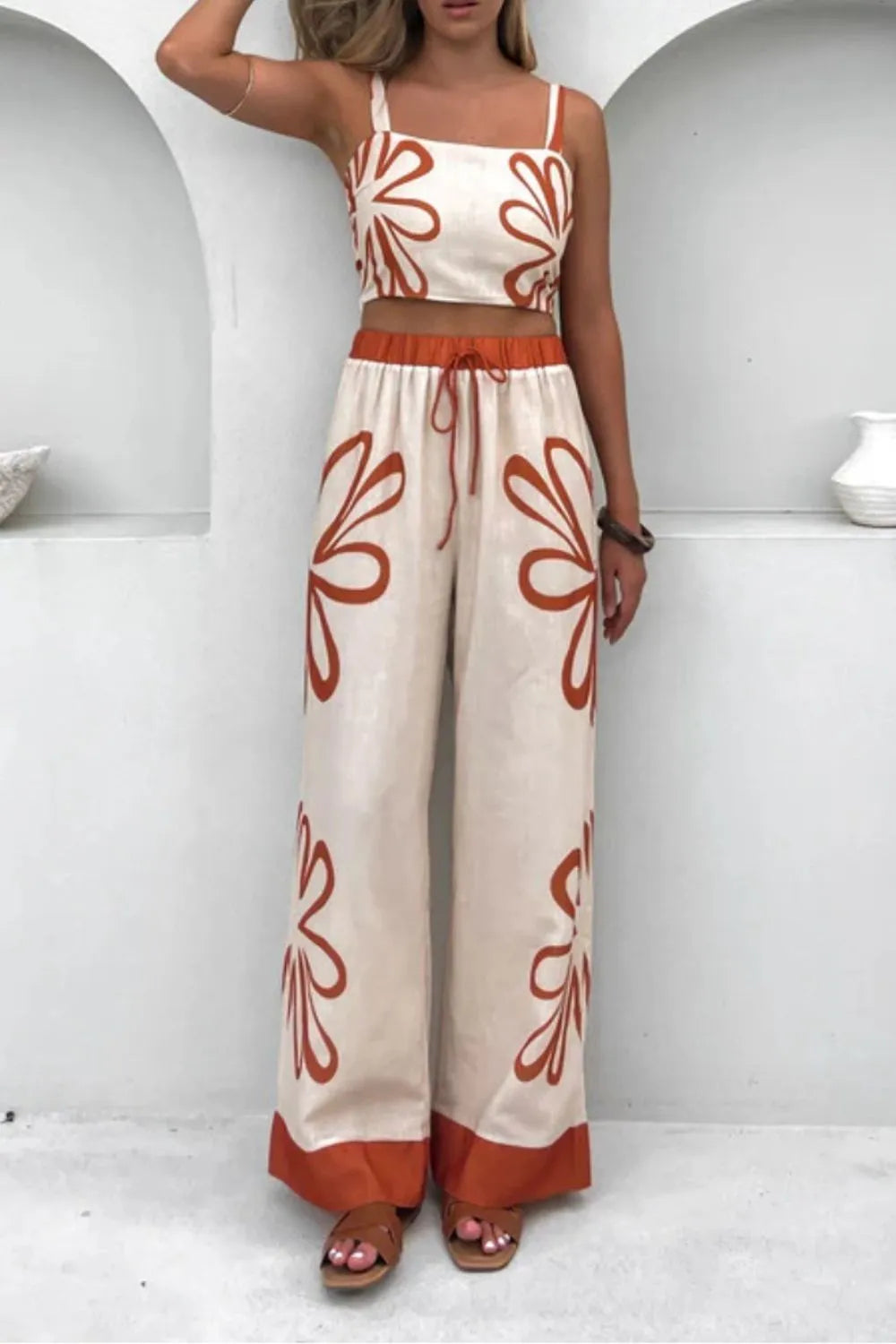 Smocked square-neck cami and pants set, two-piece; cream fabric with rust floral print and rust waistband and hem.