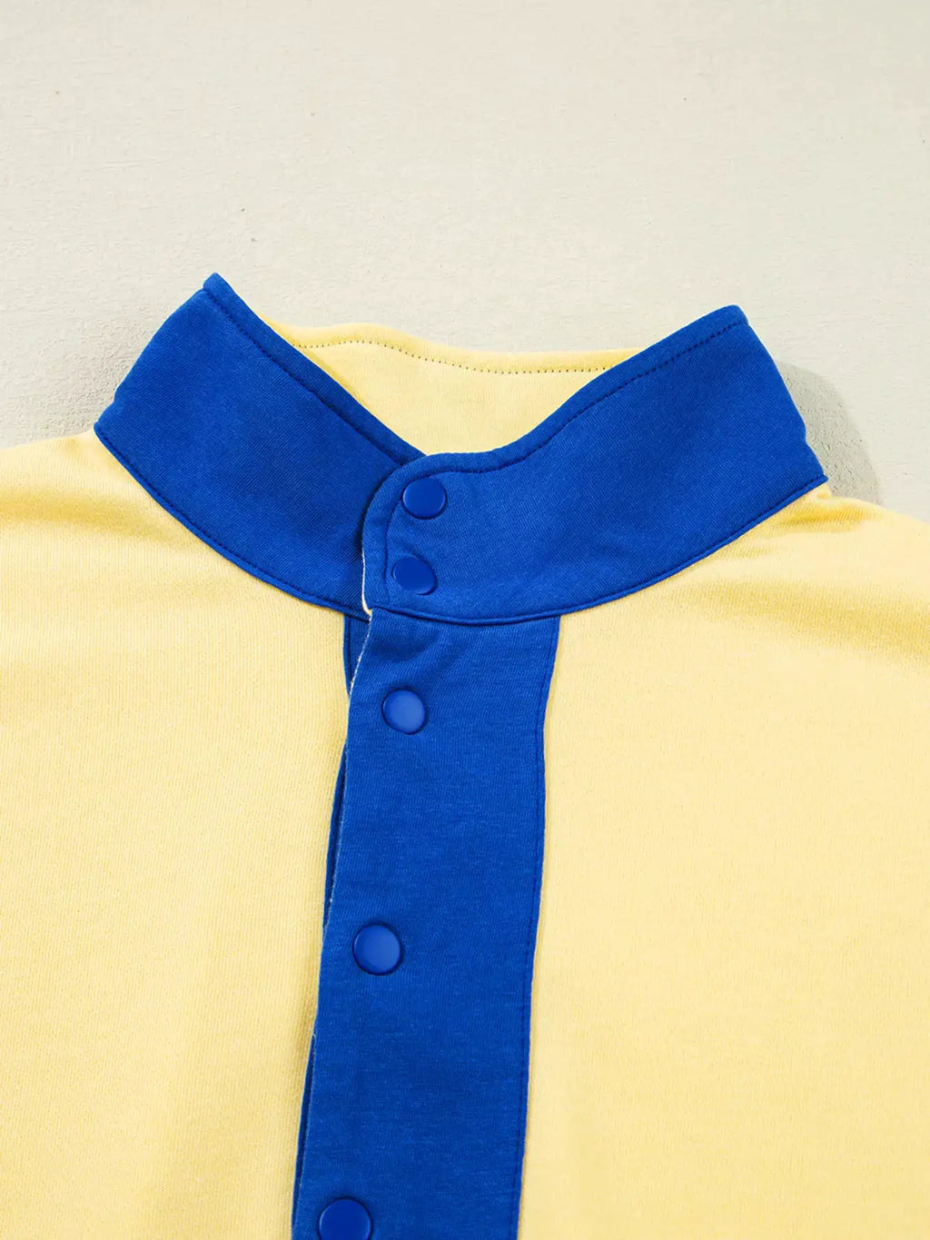 Color-block top from Belle Bijouix in yellow with blue collar and blue snap placket