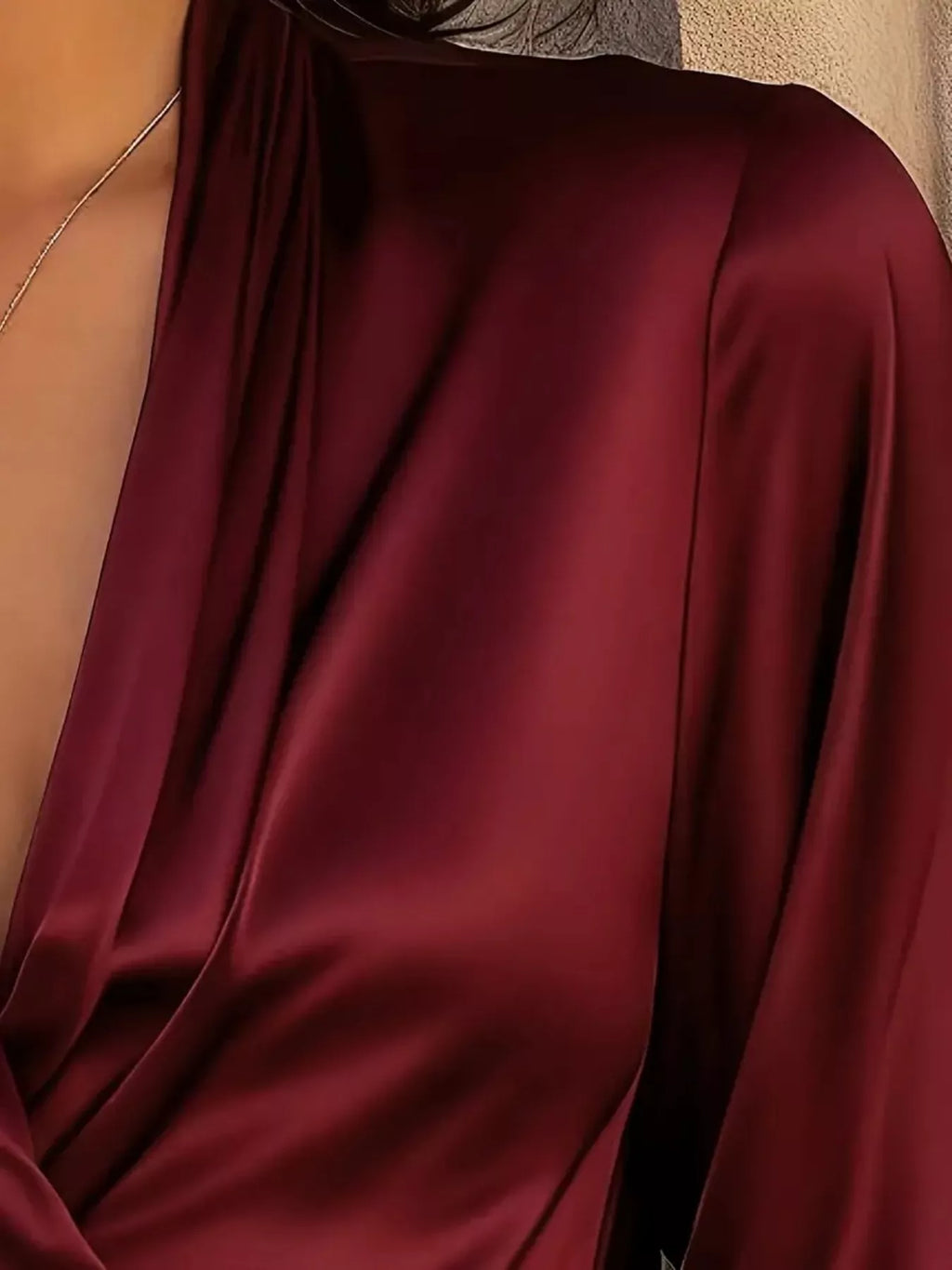 Satin surplice long-sleeve blouse in burgundy with a draped front.