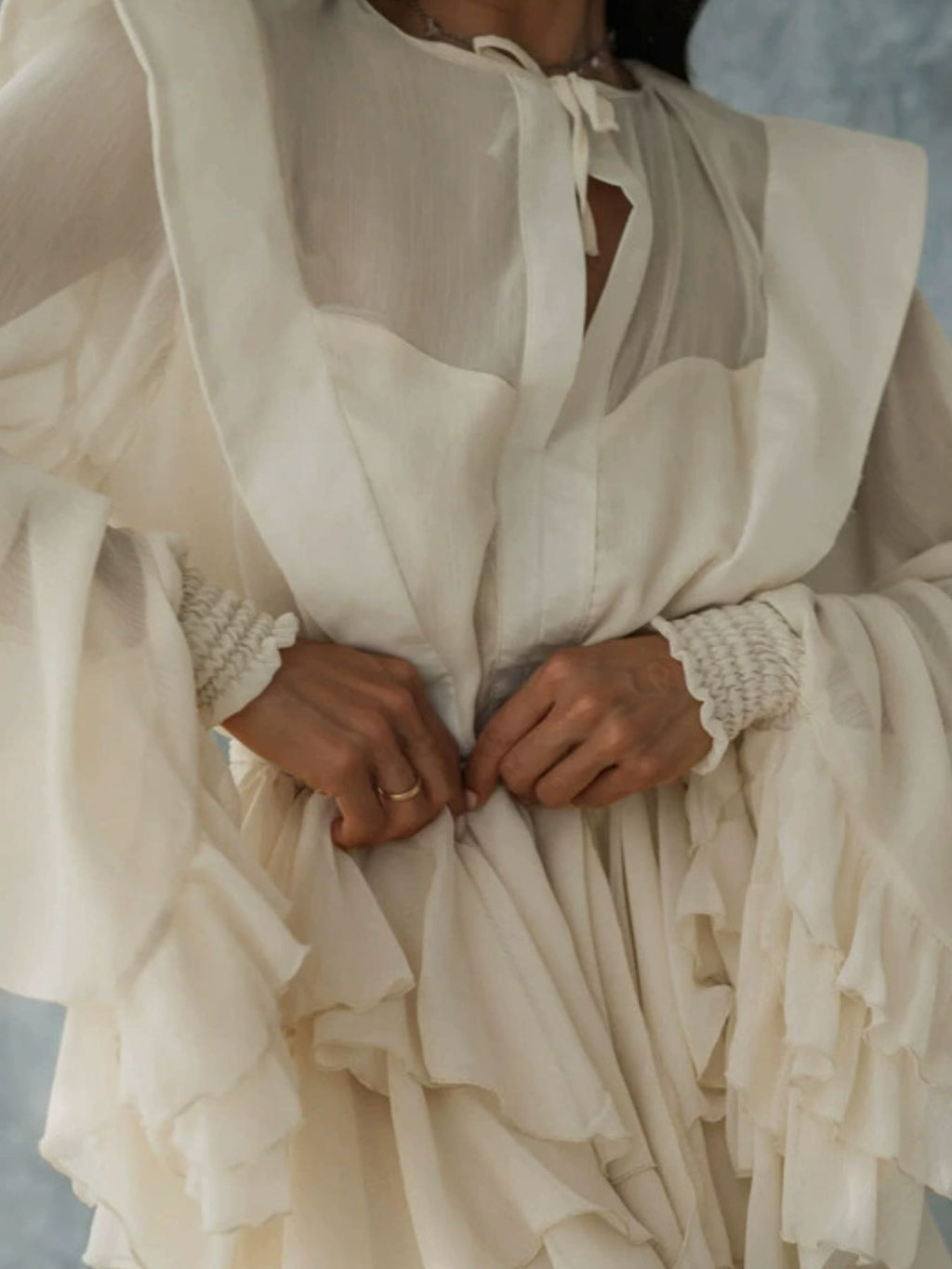 Ruffled long-sleeve cream mini dress with tie-neck and tiered sleeves