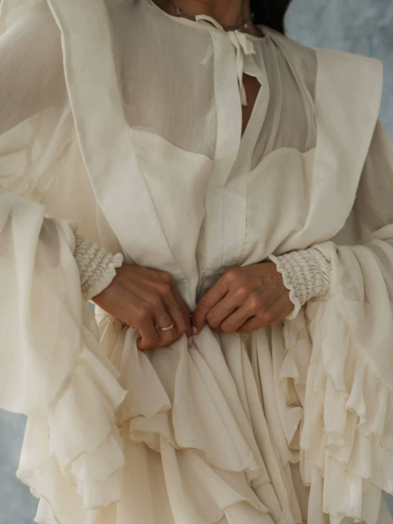 Ruffled long-sleeve cream mini dress with tie-neck and tiered sleeves
