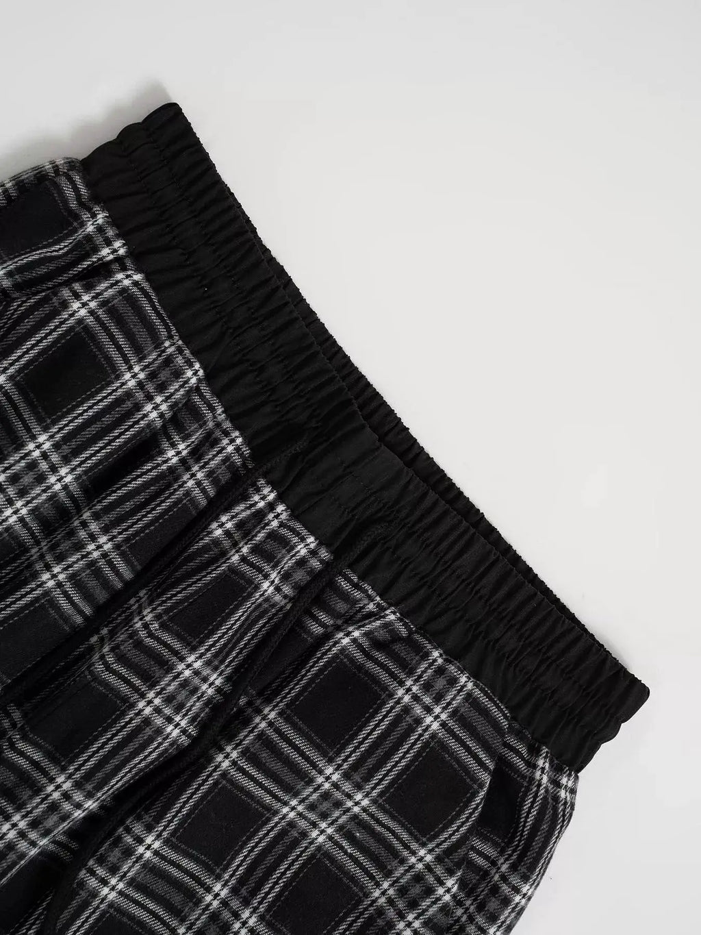 Relaxed-fit plaid pants with black elastic waistband in a black-and-white check pattern