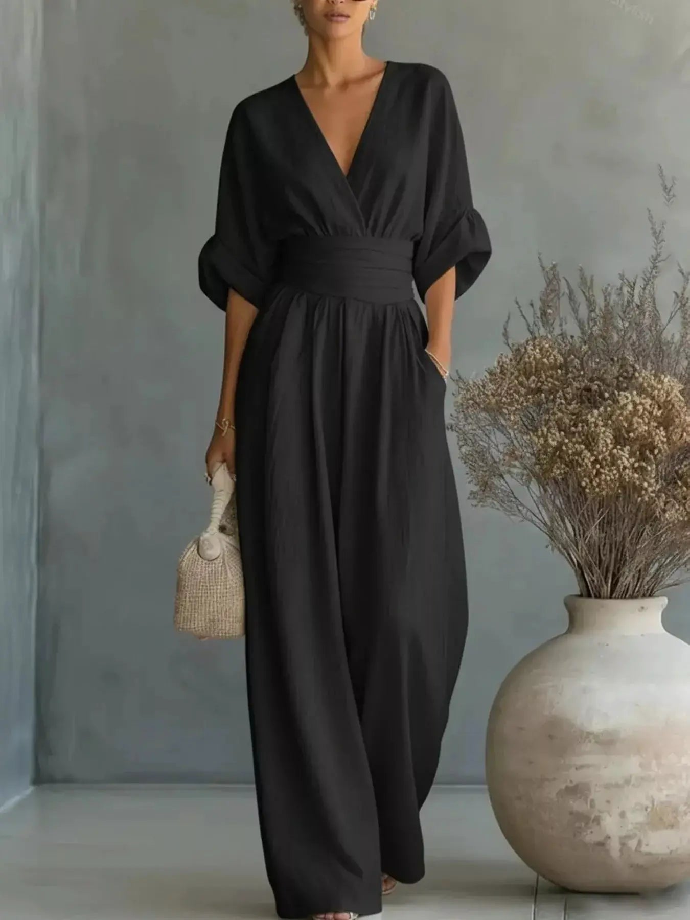 Belle Bijouix black plus-size half-sleeve wide-leg jumpsuit with a V-neck and wide waist belt.