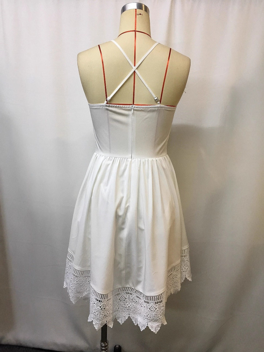 Plus-size white lace-trimmed mini dress with crisscross back straps and lace hem