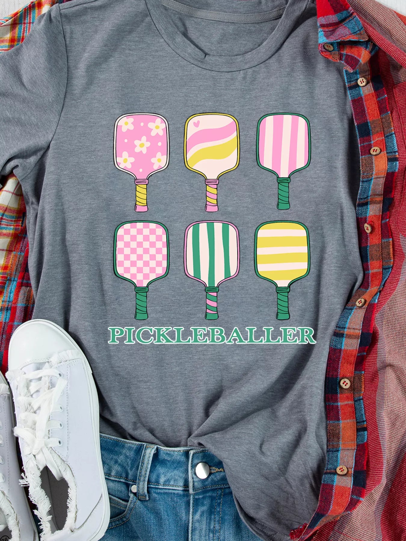 PICKLEBALLER T-shirt with six pastel paddle illustrations on heather gray.