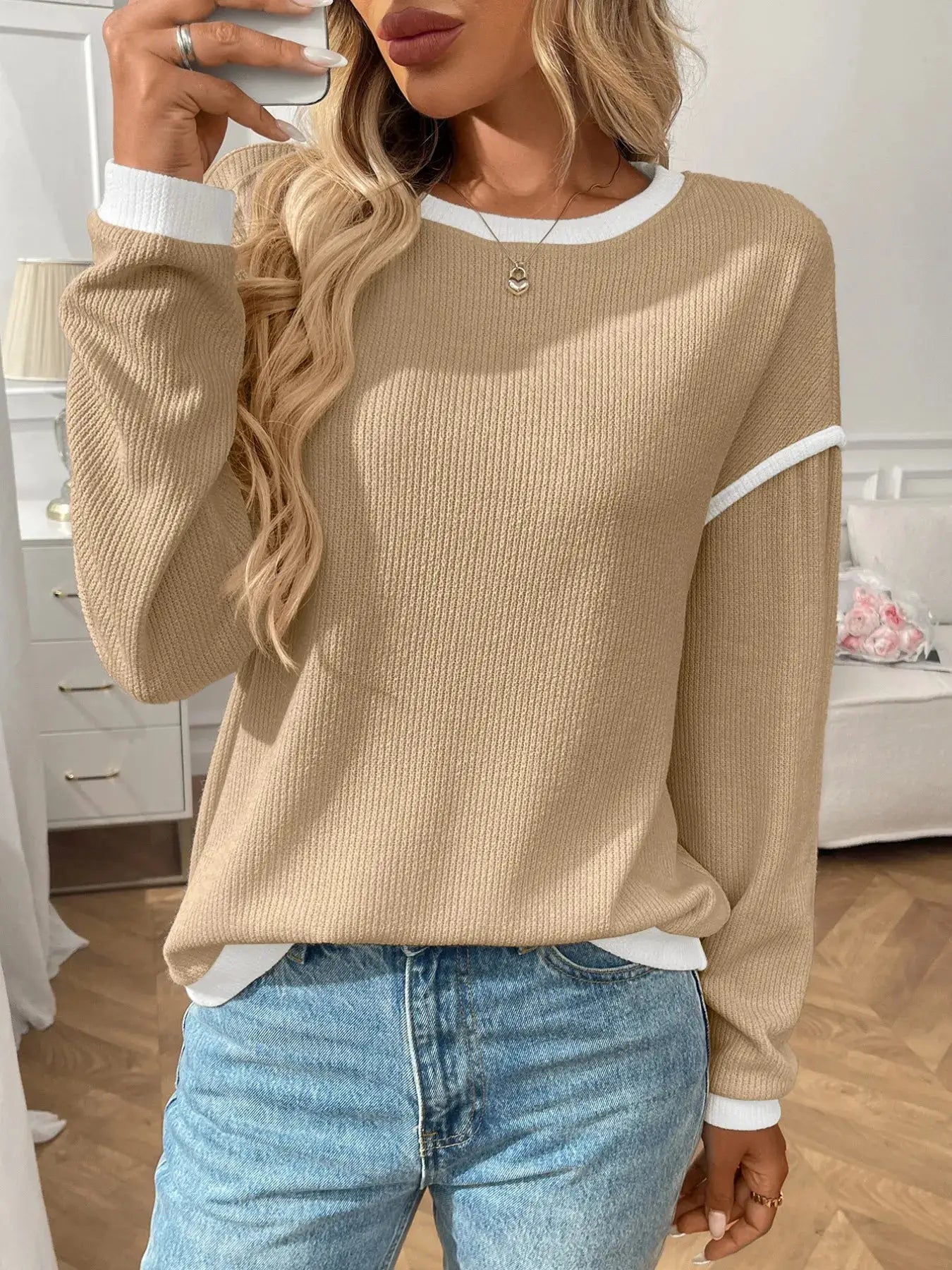 Ribbed beige long-sleeve top with white contrast trim at neckline and cuffs