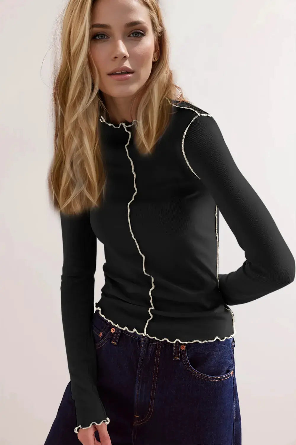 T-shirt black long-sleeve top with cream contrast trim along the mock neck and hem.