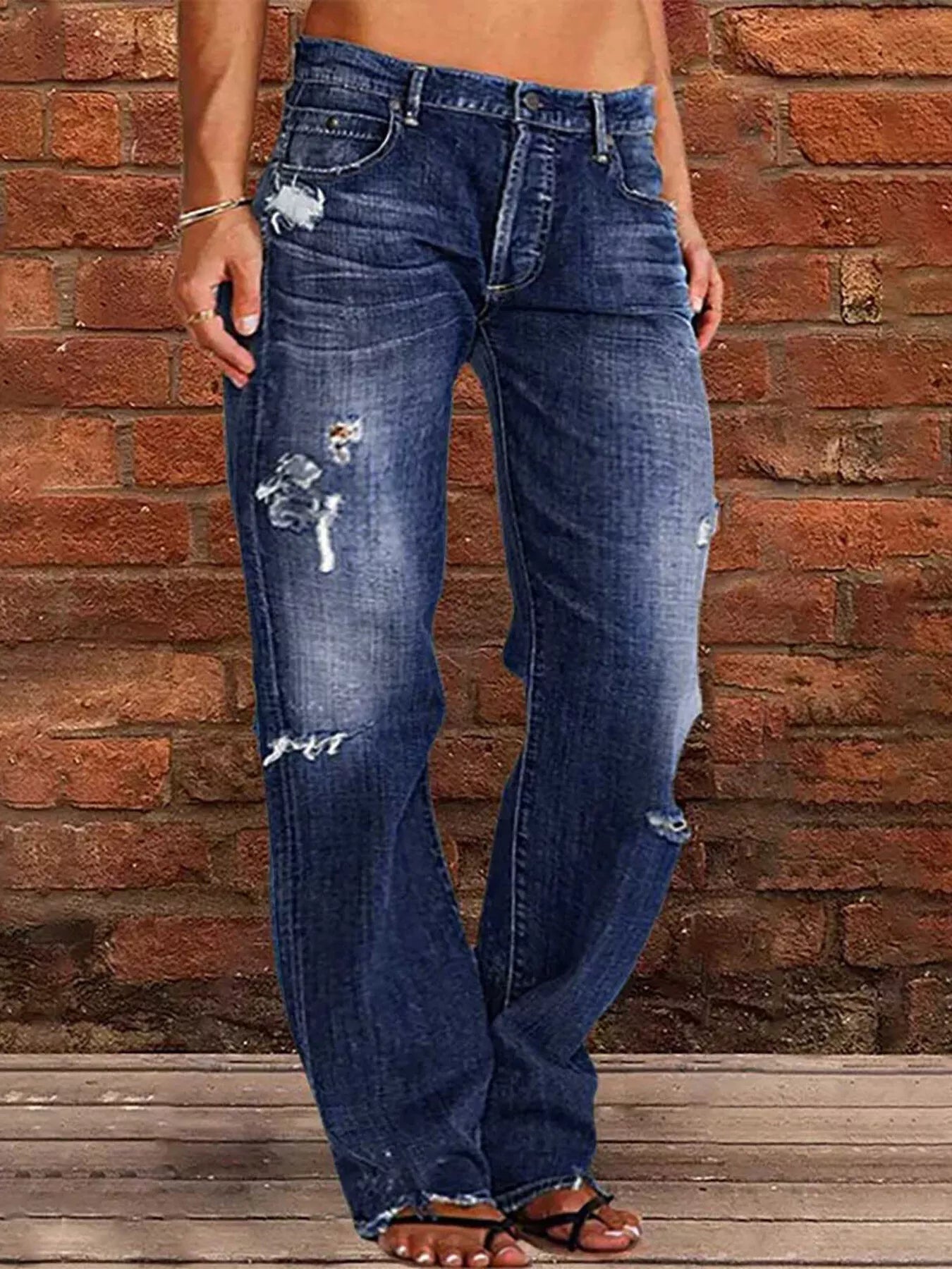 Distressed loose-fit jeans in blue denim with ripped knees and faded thighs