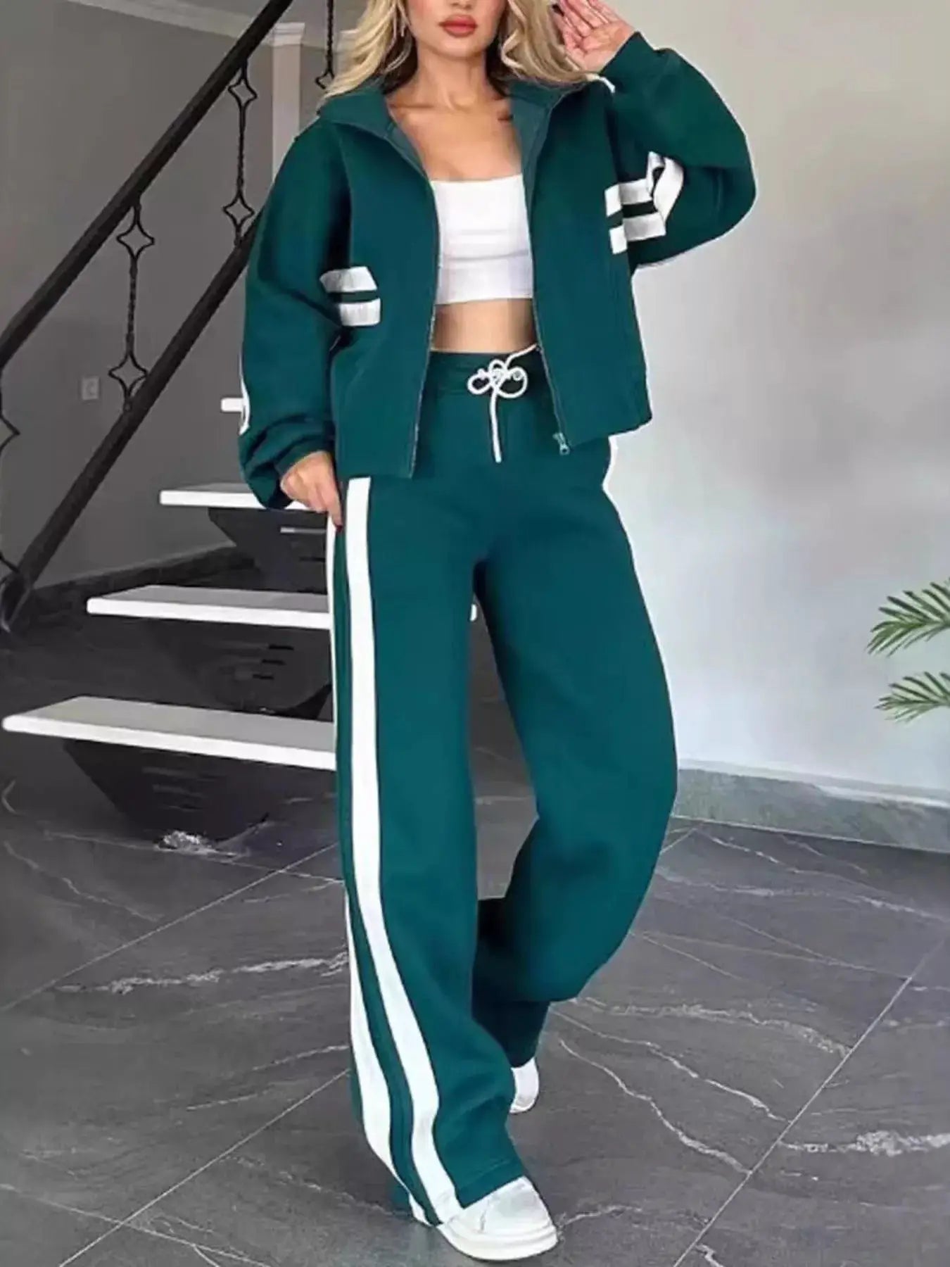 Two-piece teal striped zip-up activewear set (jacket + pants) with white side stripes.