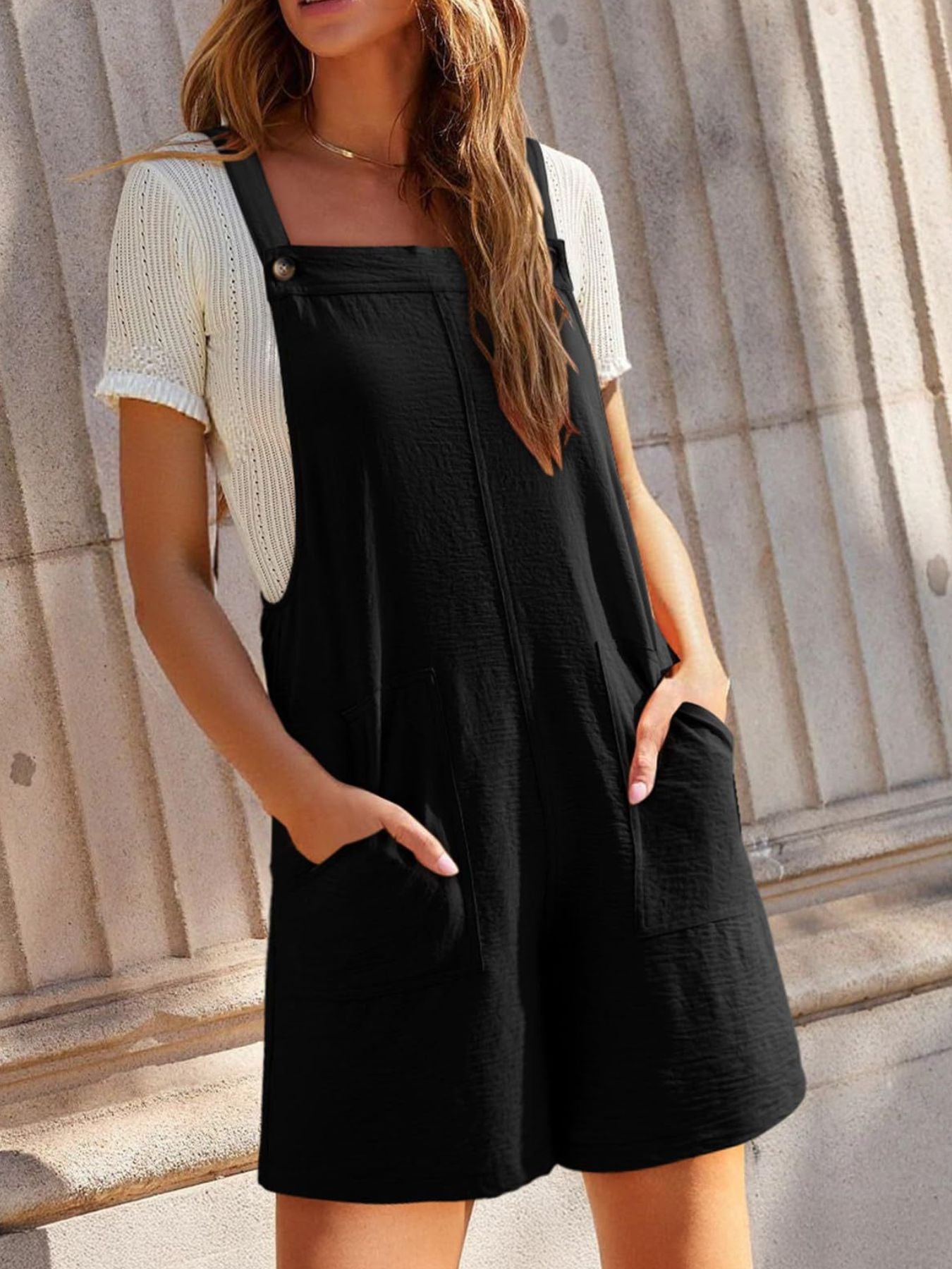Casual black wide-strap overalls with pockets, buttoned straps, shown with a white knit top