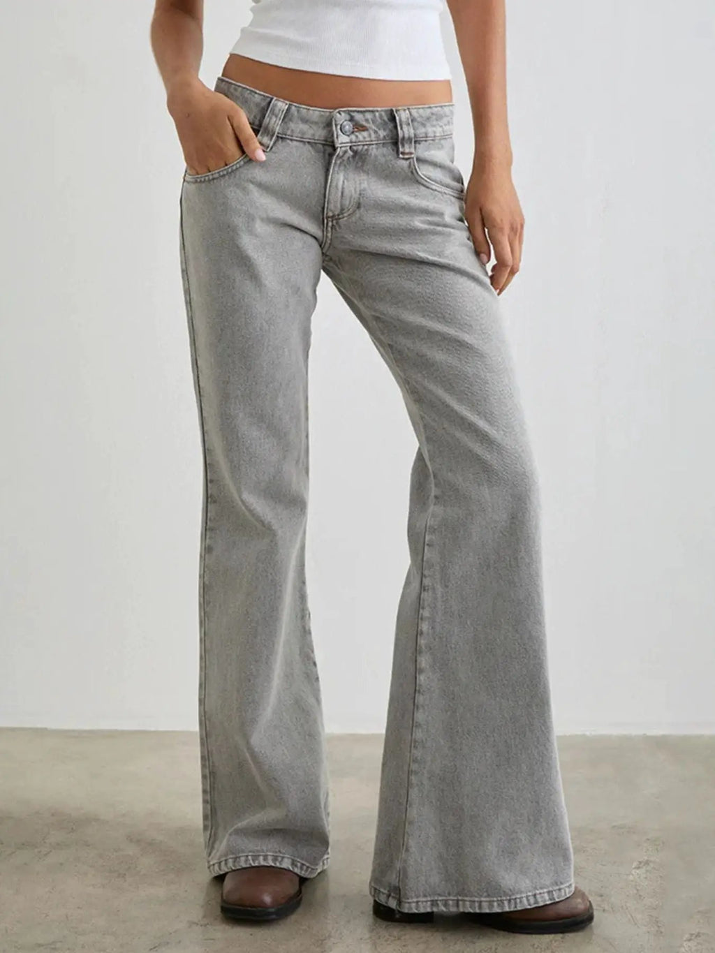 Low rise flare-leg jeans in light gray denim with pockets and buttoned details