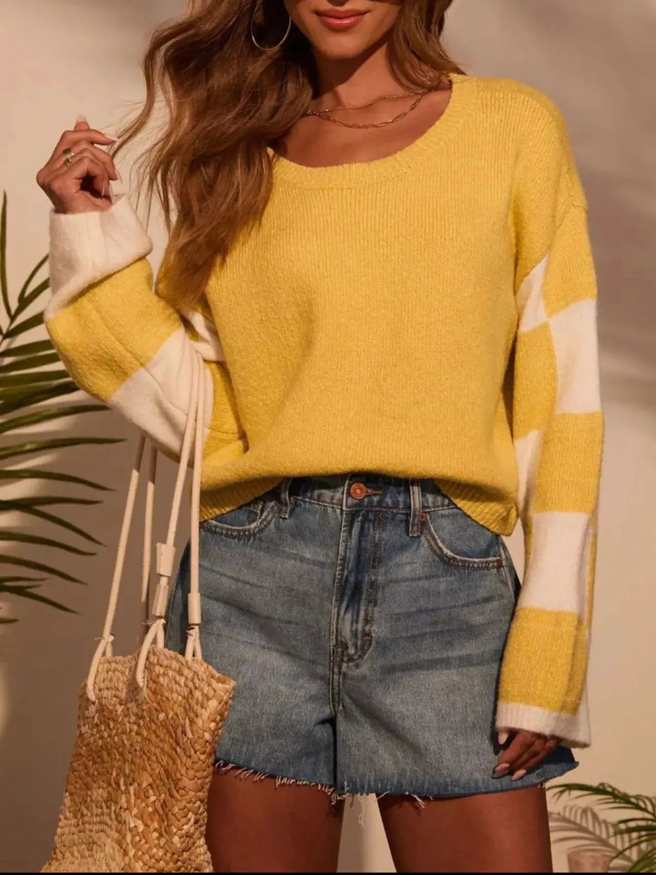 Color Block Long Sleeve Sweater in yellow with white color blocks on sleeves; model pairs with denim skirt and straw bag